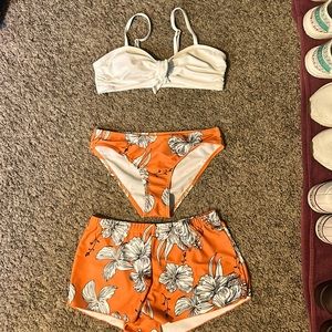 It is orange with flowers on the shorts/swim bottoms the top is white.